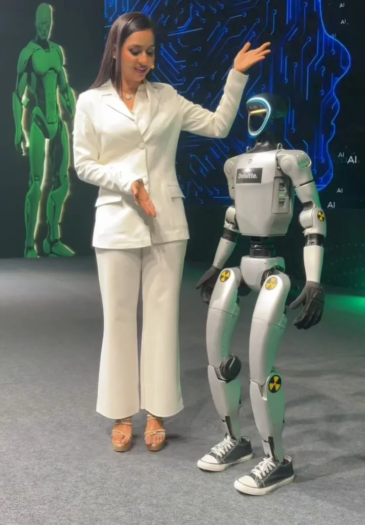 Humanoid emcee robot interacting with a host at a corporate event